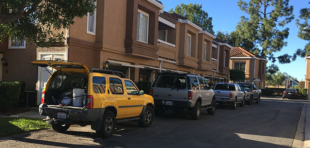 Contractor trucks parked along side of garages working to fix drywall